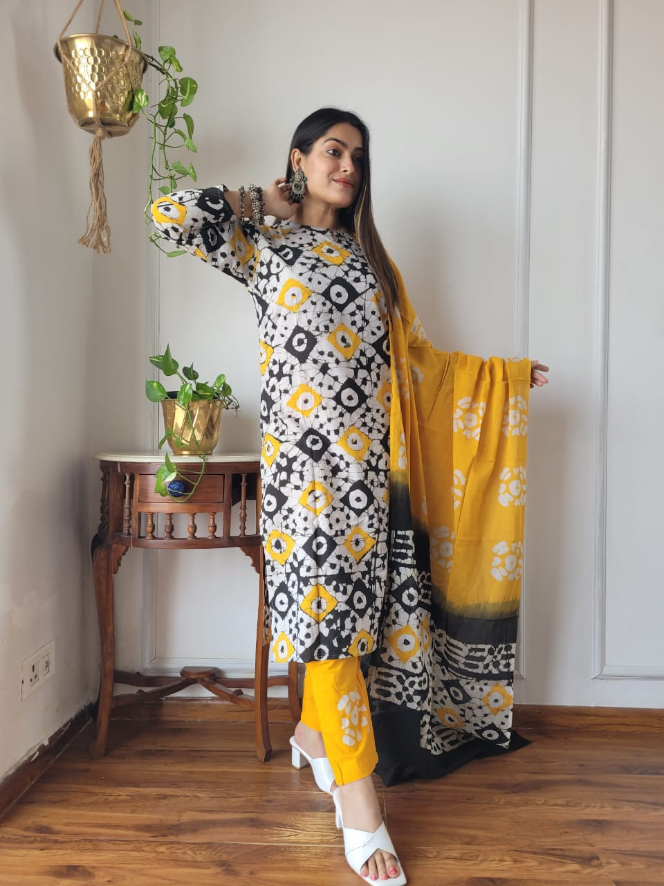 yellow, black, and white batik or block print cotton kurta, pants, and dupatta suit set.