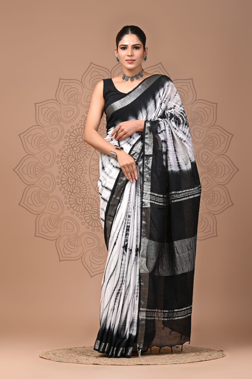 Black and White Tie-Dye or Shibori Print Saree typically crafted from a lightweight  linen fabric  and features a metallic or silver-toned border.