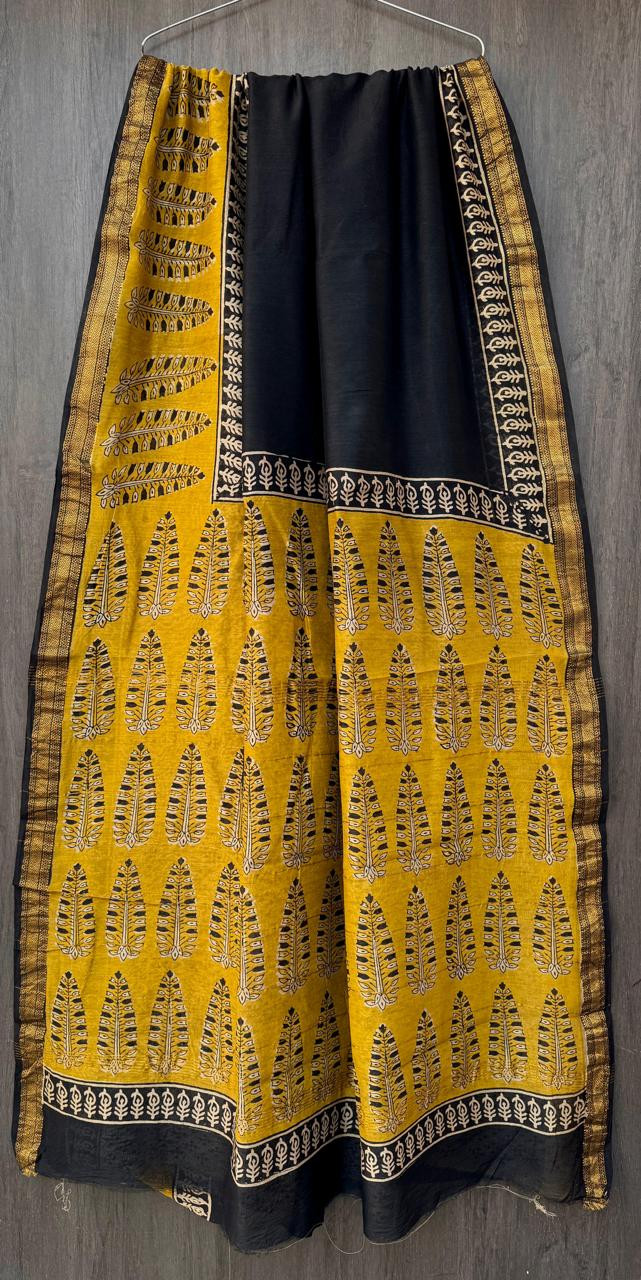 black and yellow hand-block printed Maheshwari or Chanderi silk/cotton blend saree with traditional leaf motifs and a golden zari border.